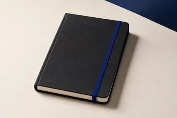 Illustrative charcoal notebook with a blue elastic band